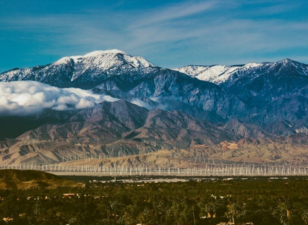 Winter landscape with brown fields in the foreground and snowcapped Sierra Nevada mountains in the background - Snow in Southern California Mt San Jacinto