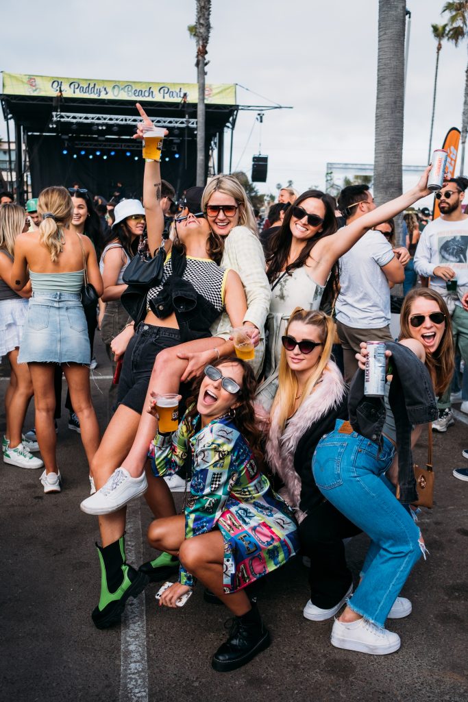 a group of young women partying in front of the stage at St Paddy's O'Beach Party