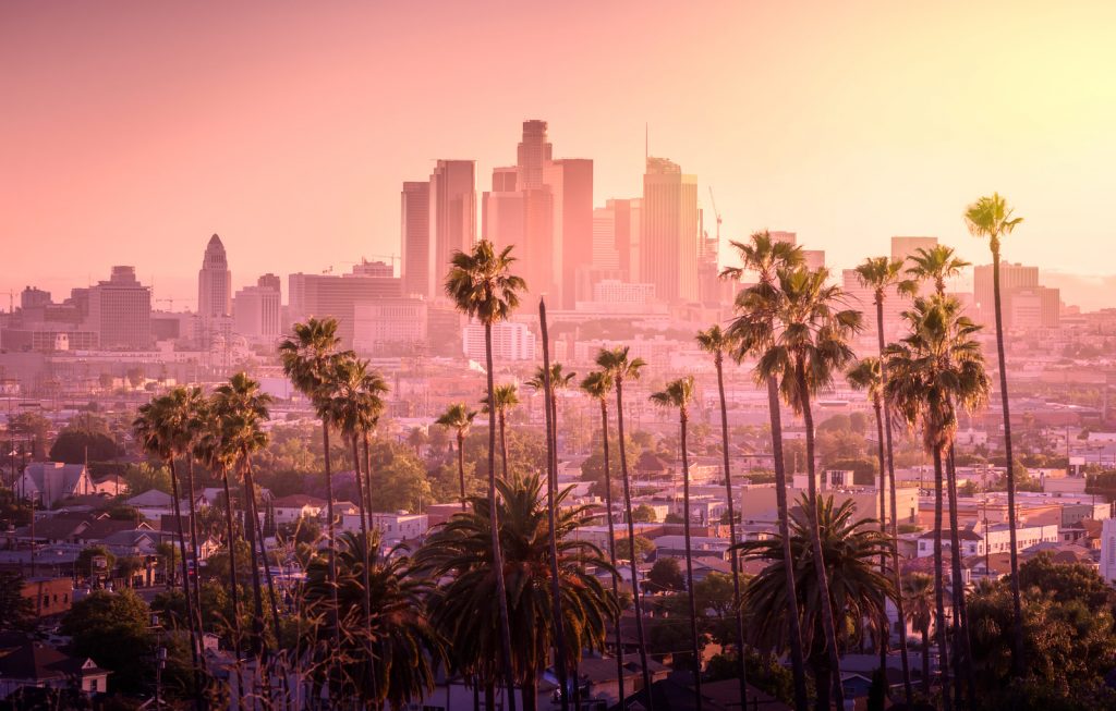 Best Weekend Trips from San Diego - Beautiful sunset of Los Angeles downtown skyline and palm trees in foreground