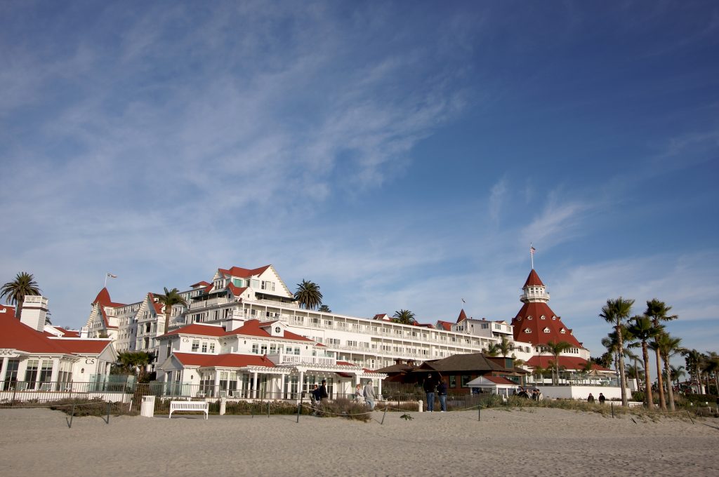 White and red building lining the beach as people check in and out