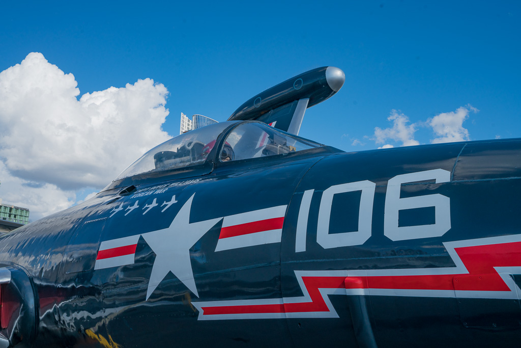 red and blue fighter pilot jet with a white star, red lightning bolt and the number 106 written on its side. 