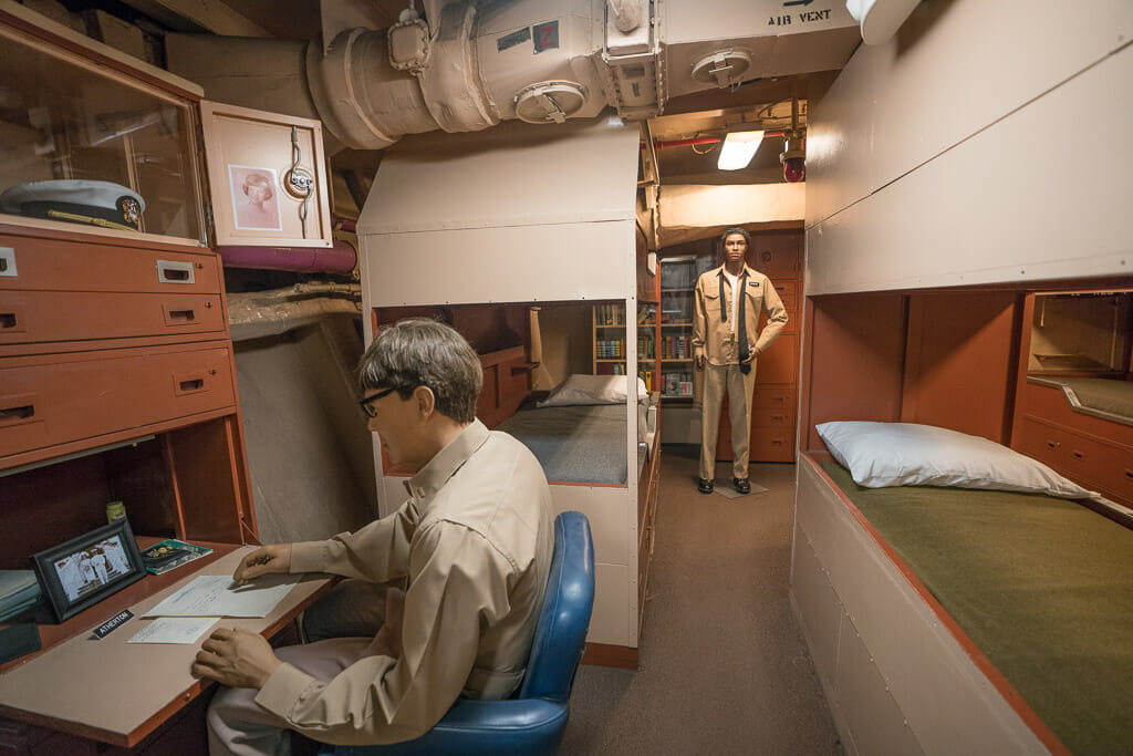 Officer quarter on the USS Midway museum with bunk beds and desk with plastic mannequins