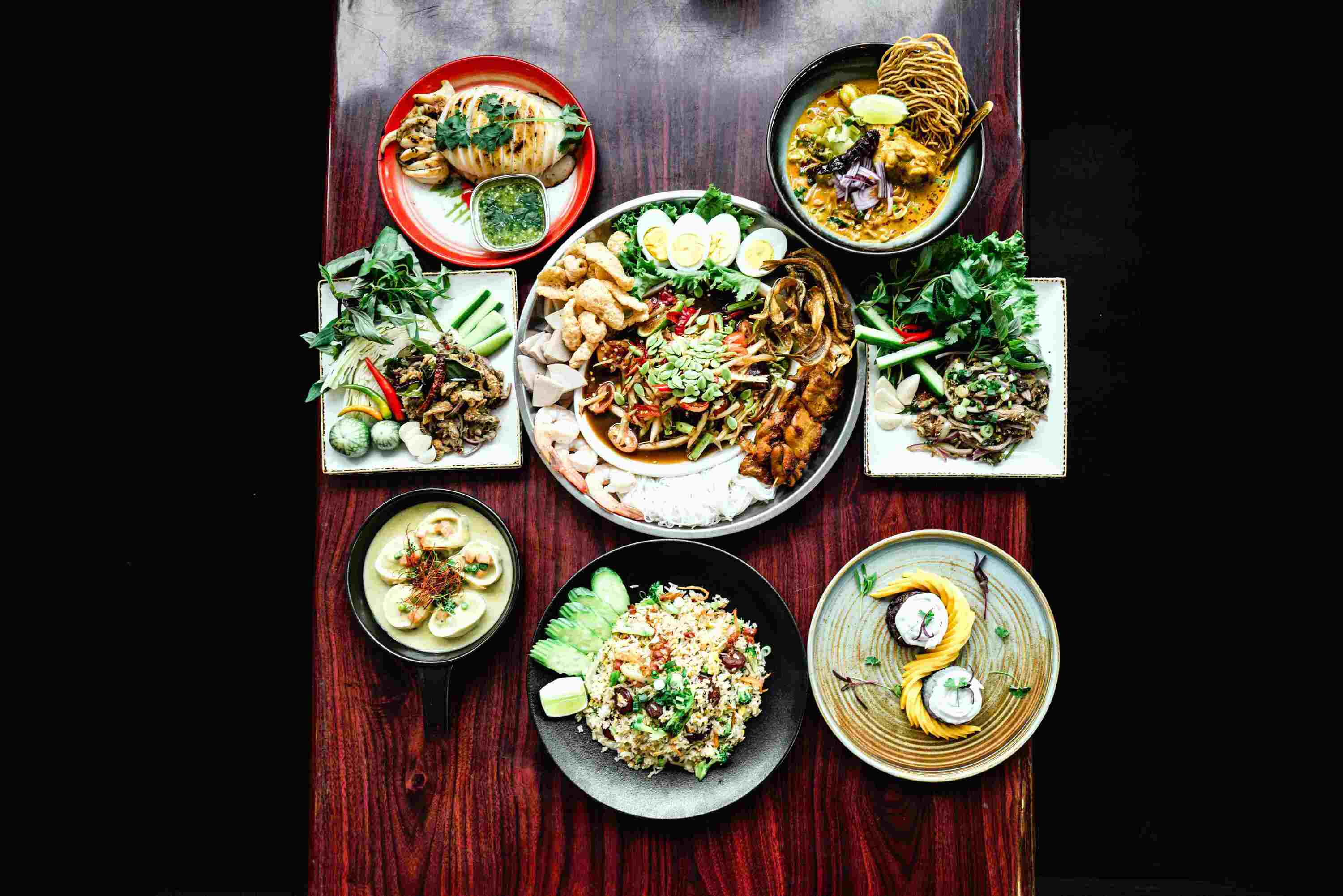 Spicy Sugar's somtum tad (center). From clockwise: Khao soi, pork namtok, mango sticky rice, chef Katt's special fried rice, green curry dumplings, duck larb and whole grilled squid.
