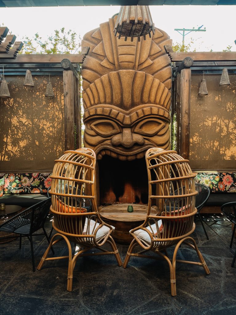 Polynesian face mask and rattan chairs at The Grass Skirt San Diego Speakeasy