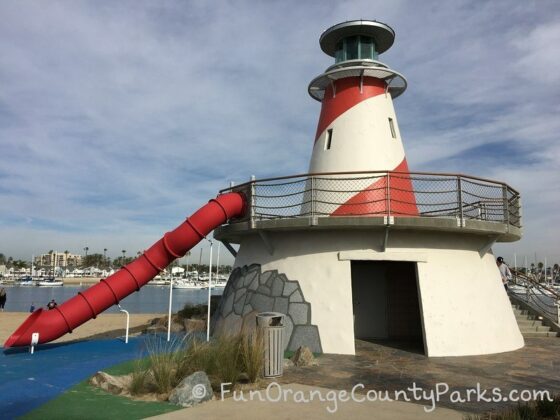 Marina Park bathroom building with a lighthouse on top and red tunnel slide