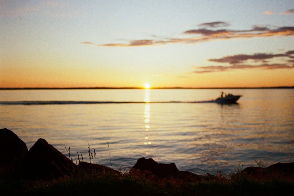 Sun sets over the water in Bellingham, WA with a boat in the distance 