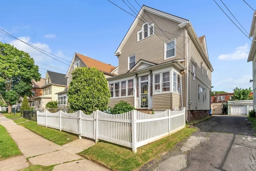 three story home with fenced in yard