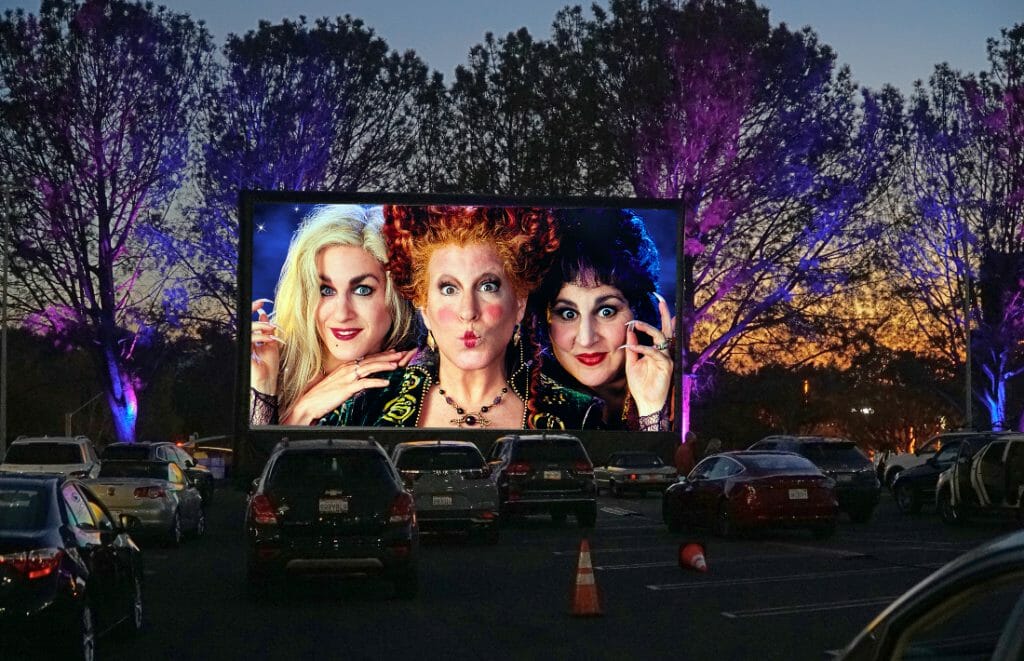 Drive in movie theatre, screen showing a scene from Witches of Eastwick