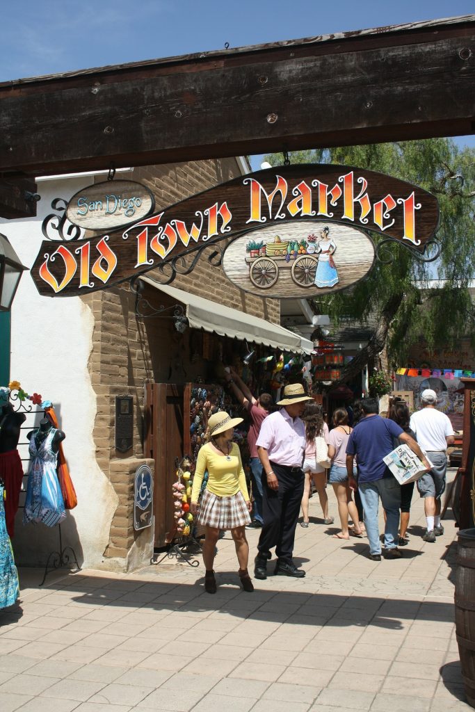 People wandering around San Diego's Old Town with the sign saying "Old Town Market" overhead