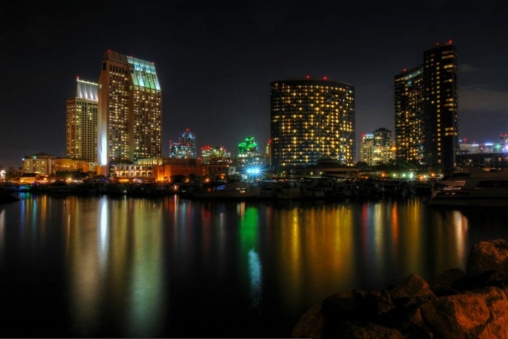 The night lights of the San Diego skyline twinkle and reflects against the water