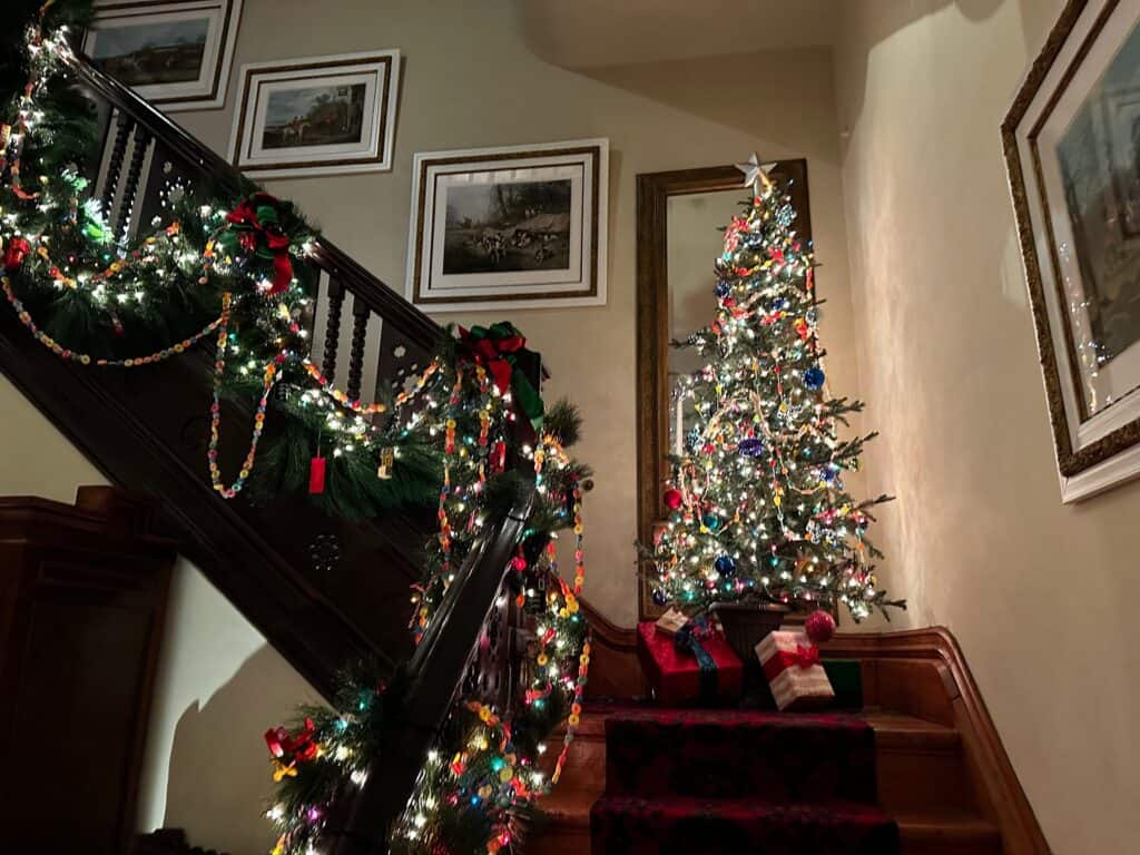 garland arranged on a railing with a tree on the stairwell