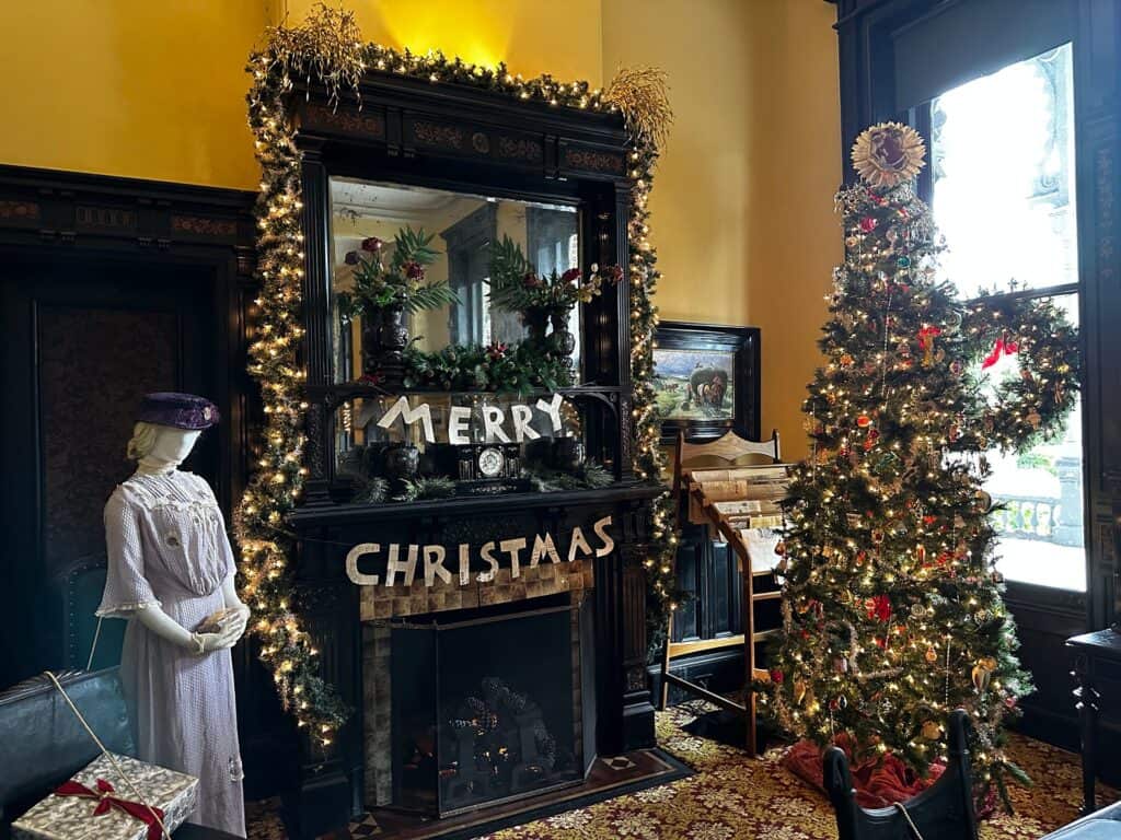 A christmas arrangement with garland and a tree covered in ornaments 