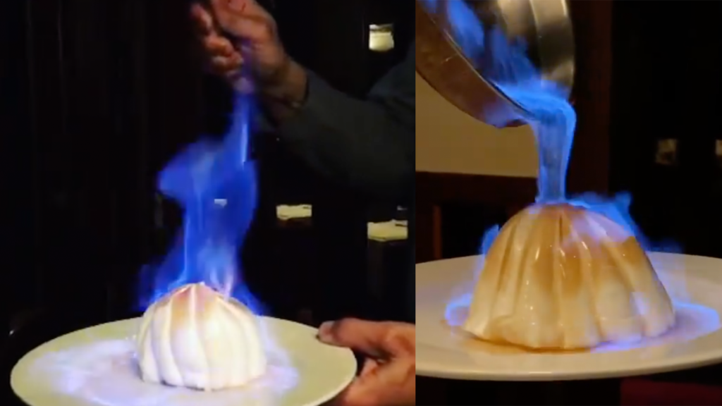 a dessert covered in ice cream set on fire table side