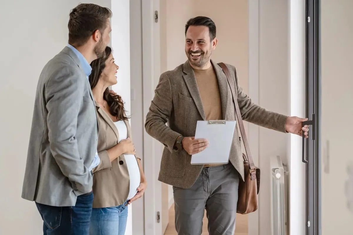 A couple with a real-estate agent visiting an apartment for sale