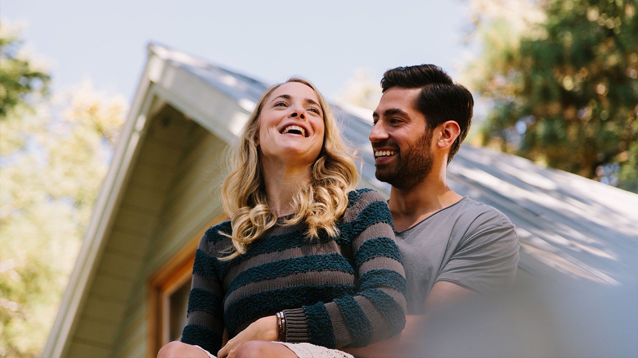 Gen X couple in front of their home