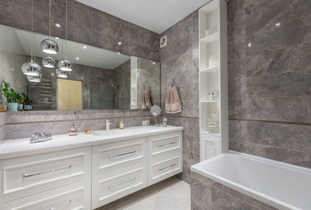 Interior of a contemporary bathroom with white furniture and bathtub