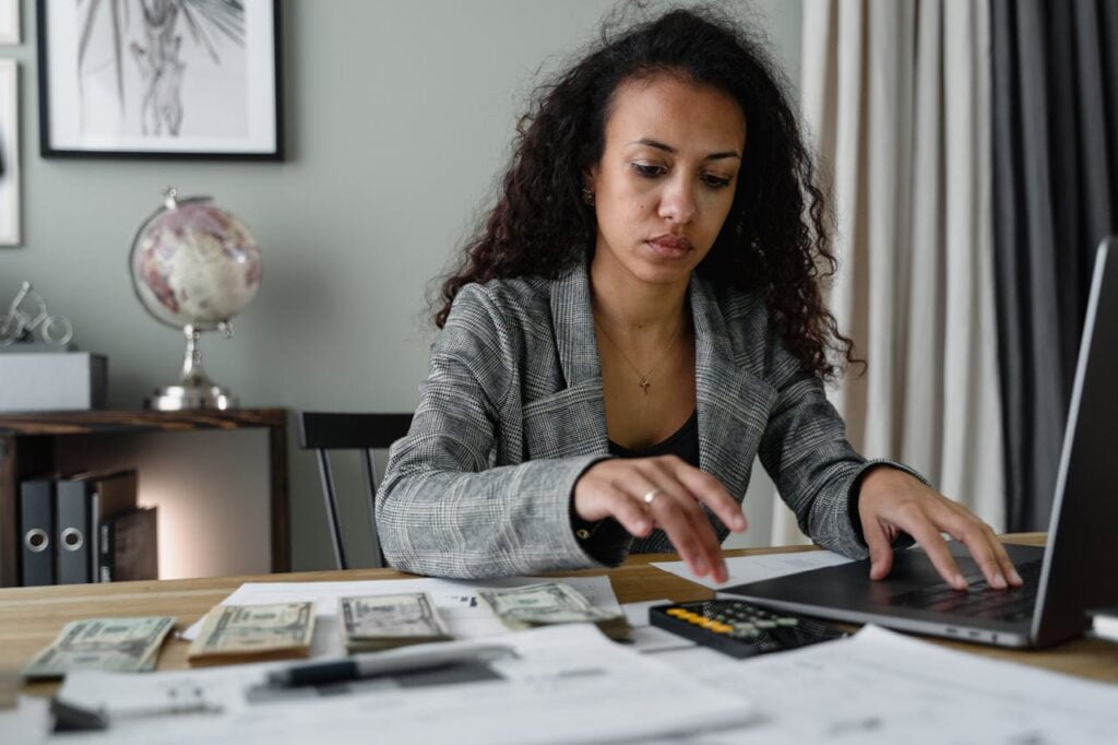 Woman budgeting using her laptop and calculator