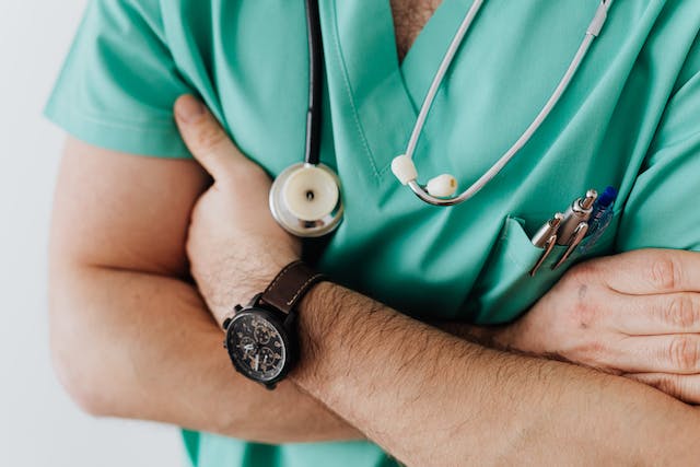 Doctor in a green uniform with a stethoscope around his neck