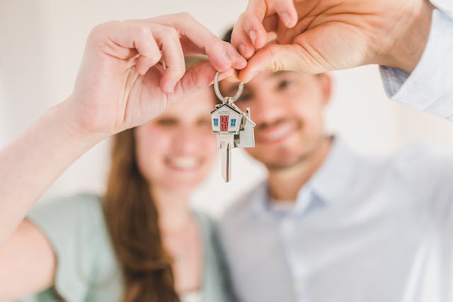 A couple holds the keys to a newly purchased house