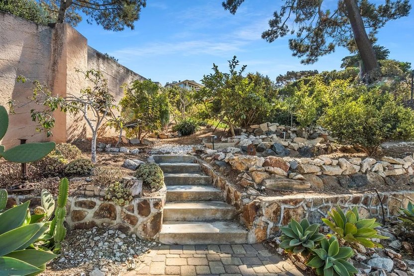 Pathways lined with stone and mature foliage winding throughout the 1/3 acre, terraced lot.