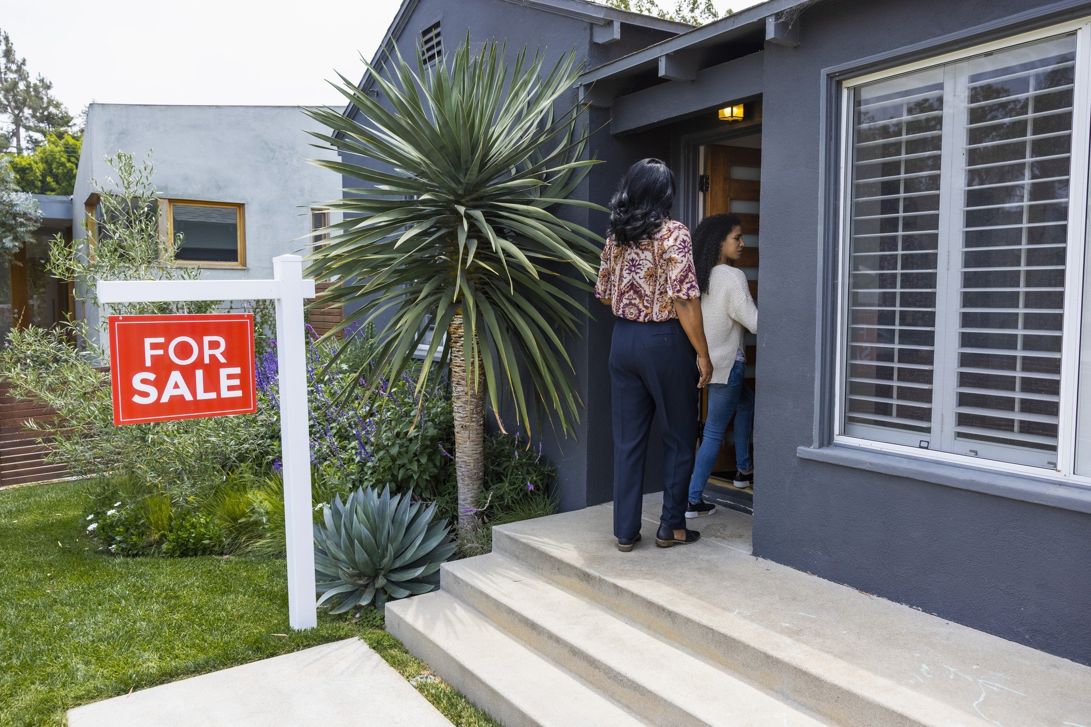 Mother and adult daughter looking at home for sale