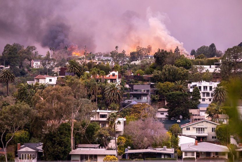 PACIFIC PALISADES, CALIFORNIA - JANUARY 08: Flames from the Palisades Fire approach homes on January 08, 2025 in Pacific Palisades, California. Fueled by intense Santa Ana Winds, the Palisades Fire has grown to over 2,900 acres and 30,000 people have been ordered to evacuate while a second major fire has emerged near Eaton Canyon and Altadena. (Photo by Tiffany Rose/Getty Images)