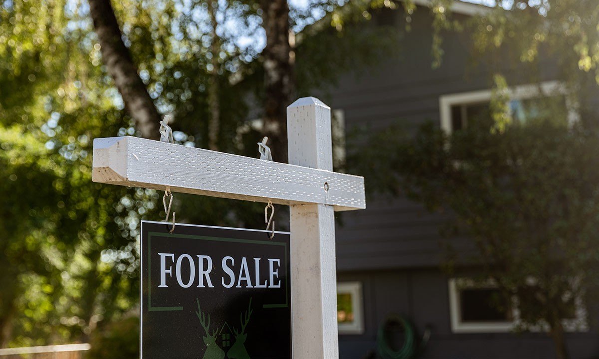 A home with a for sale sign in front