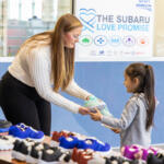 Sonja Harrell giving out shoes at the Wyatt Johnson Subaru shoe and sock giveaway on January 17, 2024. (Wesley Irvin)
