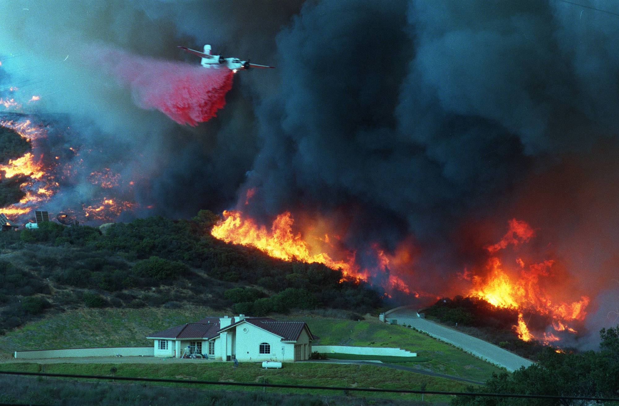 The Harmony fire burns near a home on Oct. 21, 1996. (Scott Linnett / U-T file)