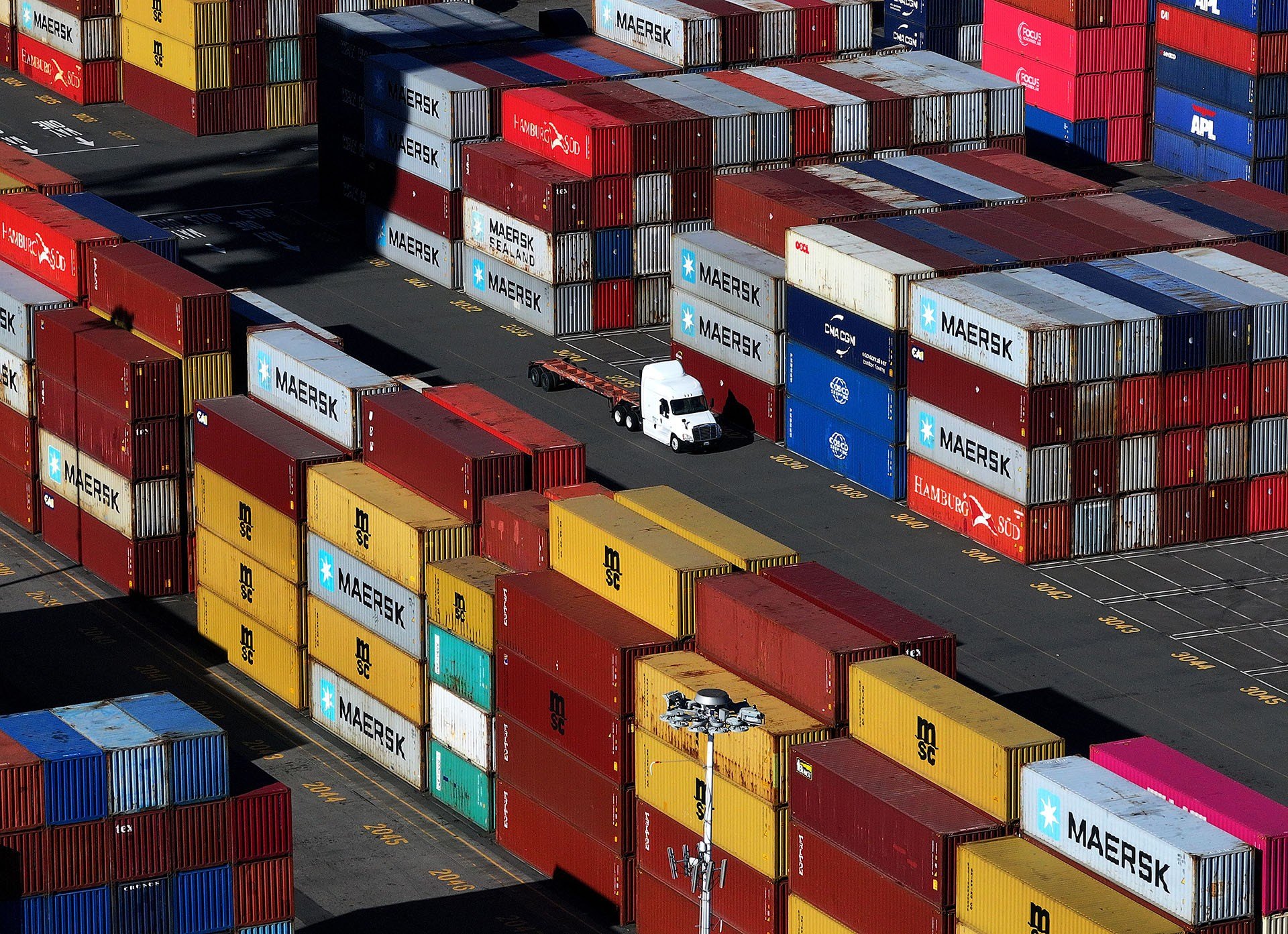 In an aerial view, shipping containers are stacked on a dock at the Port of Oakland on December 09, 2024 in Oakland, California. U.S.