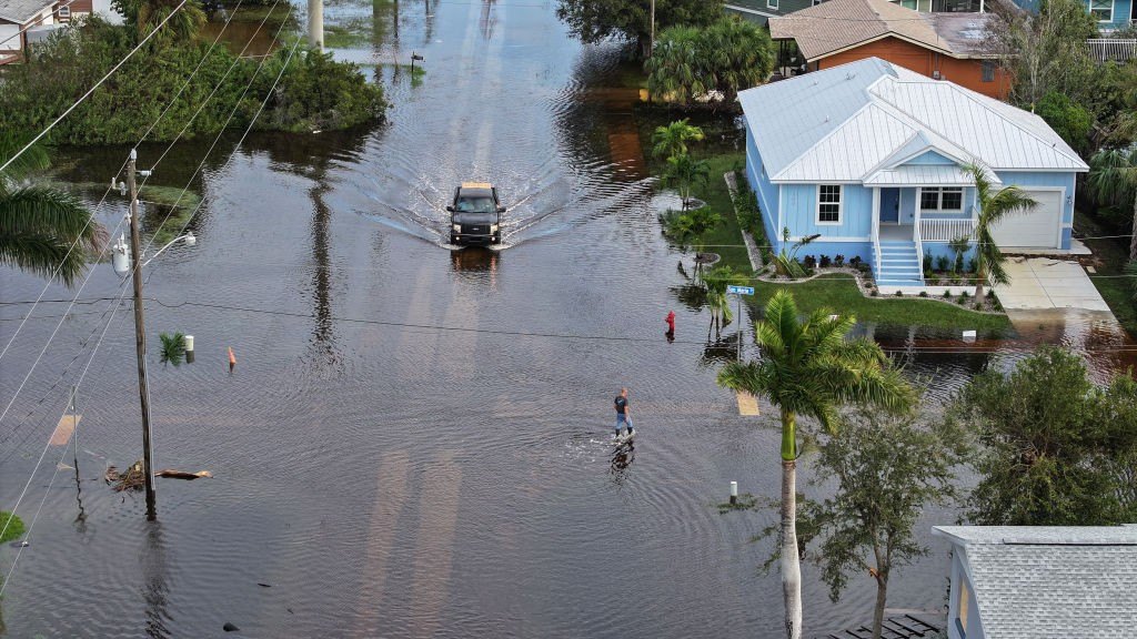 In this aerial view, a person walks through flood waters that inundated a neighborhood after Hurricane Milton