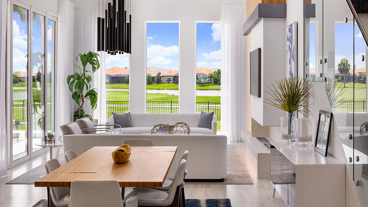 Luxury home interior; dining room and open kitchen with views out of many windows; representing the luxury real estate niche