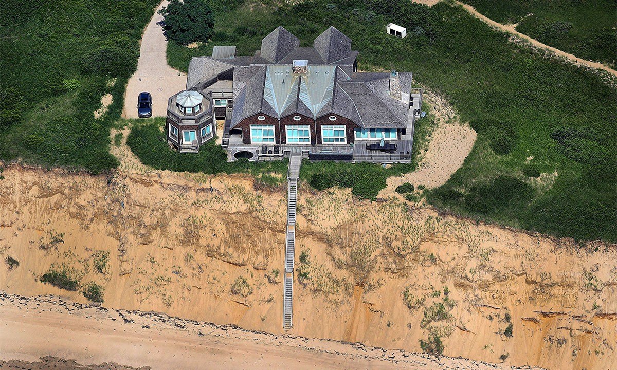 n aerial view shows a mansion perched precariously on an eroding dune near Great Island trail off Chequesset Neck Road in Wellfleet, MA