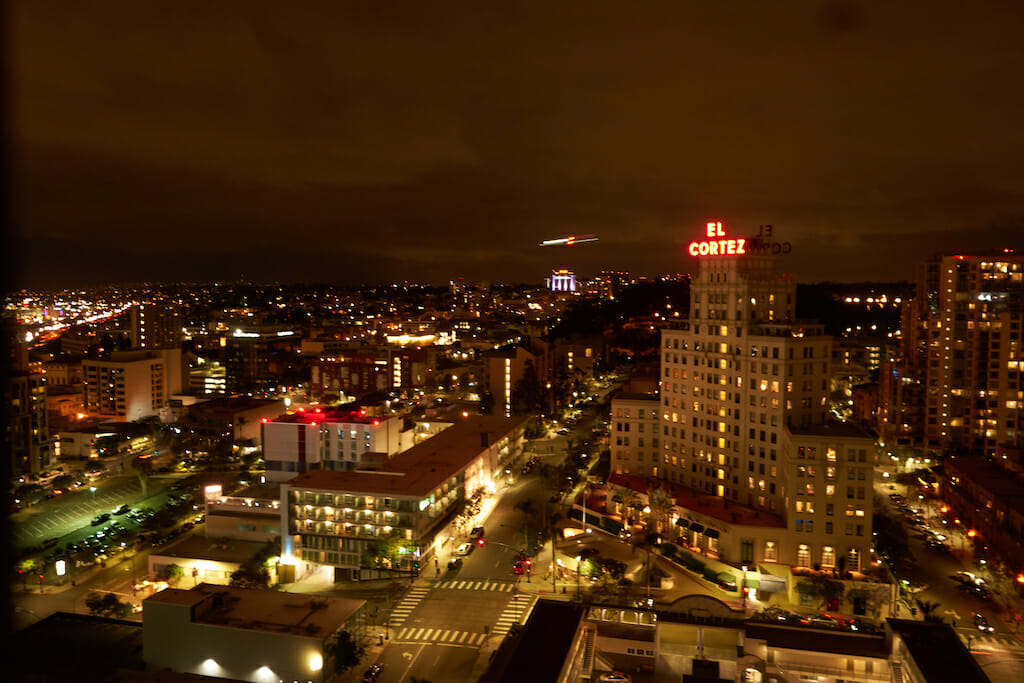 The lights radiate from the buildings as the hum of cars and people buzz below on a San Diego night