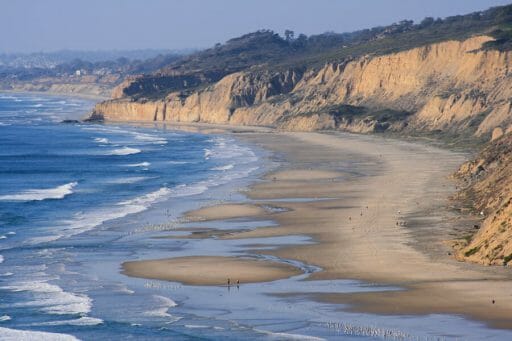 The water washes over the beaches surrounded by cliffs