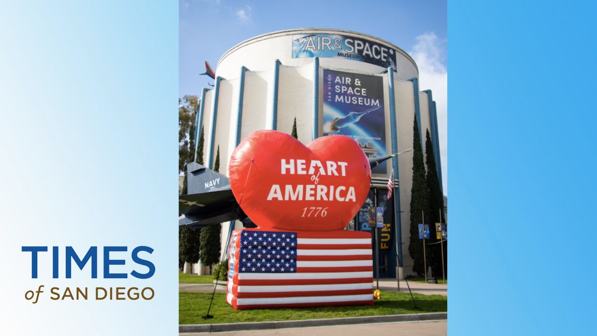 Entrance of the Air & Space Museum with a large heart-shaped inflatable and a partial view of a navy airplane.