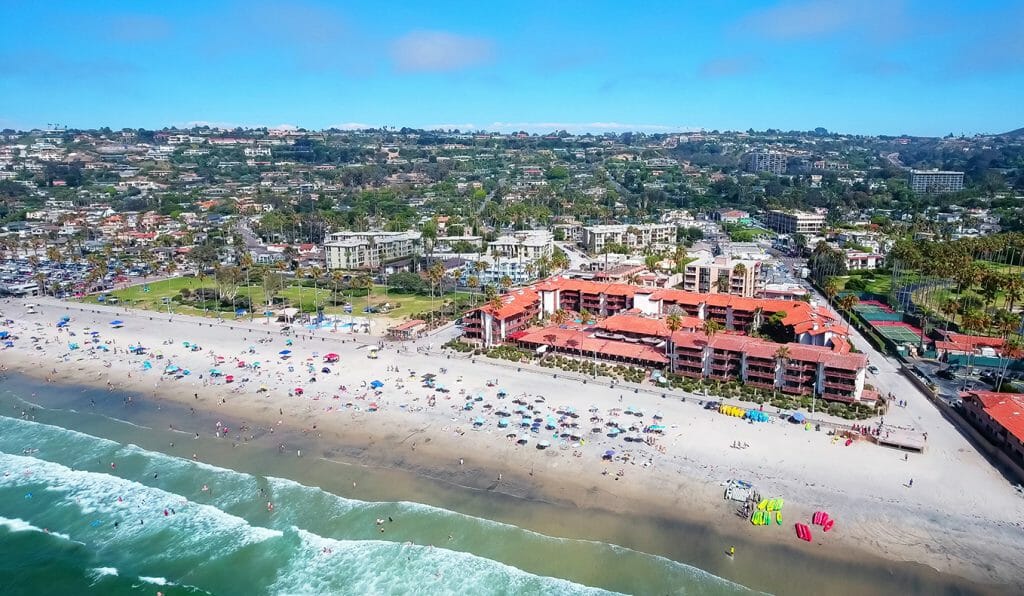 La Jolla Shores Hotel from the Air - Large 2 to 4 story hotel complex with red tiled roof directly on the beach