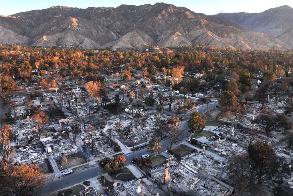 An aerial view of the sun rising beyond homes which burned in the Eaton Fire on January 21, 2025 in Altadena, California