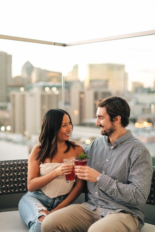 Couple m/f drinking cocktails on a San Diego Rooftop Bar The Nolen