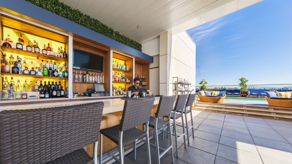 Modern hotel bar with open path to hotel pool