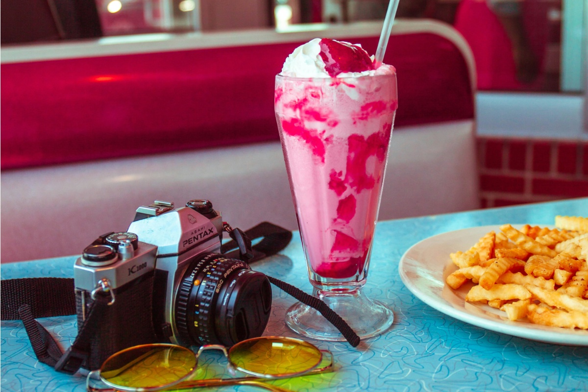 Camera, shake, and fries on the table