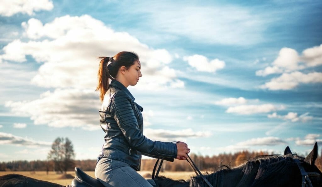 Teenage girl taking riding lessons