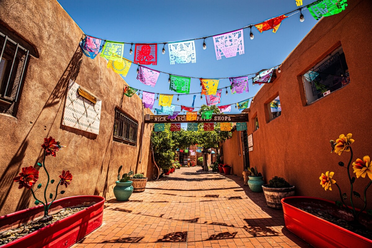 Albuquerque, New Mexico - May 17, 2021: The sun beats down on the adobe style buildings in Poco Apoco Plaza in the historic Old Town section of Albuquerque, New Mexico.