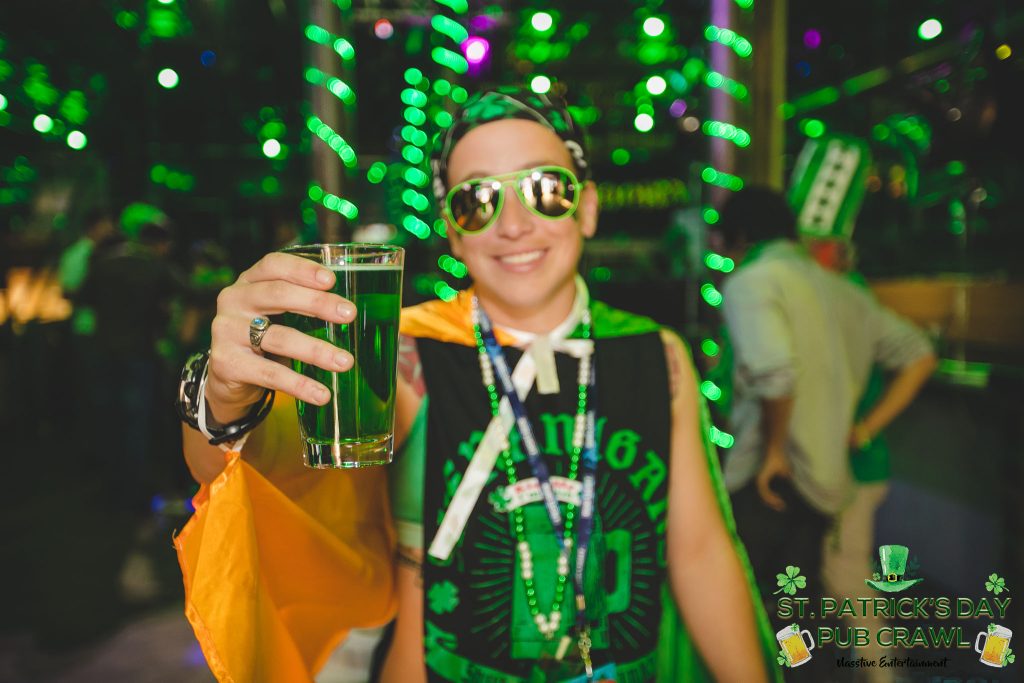 young man with a glass of green beer at a party with green St Patricks Day Accessories