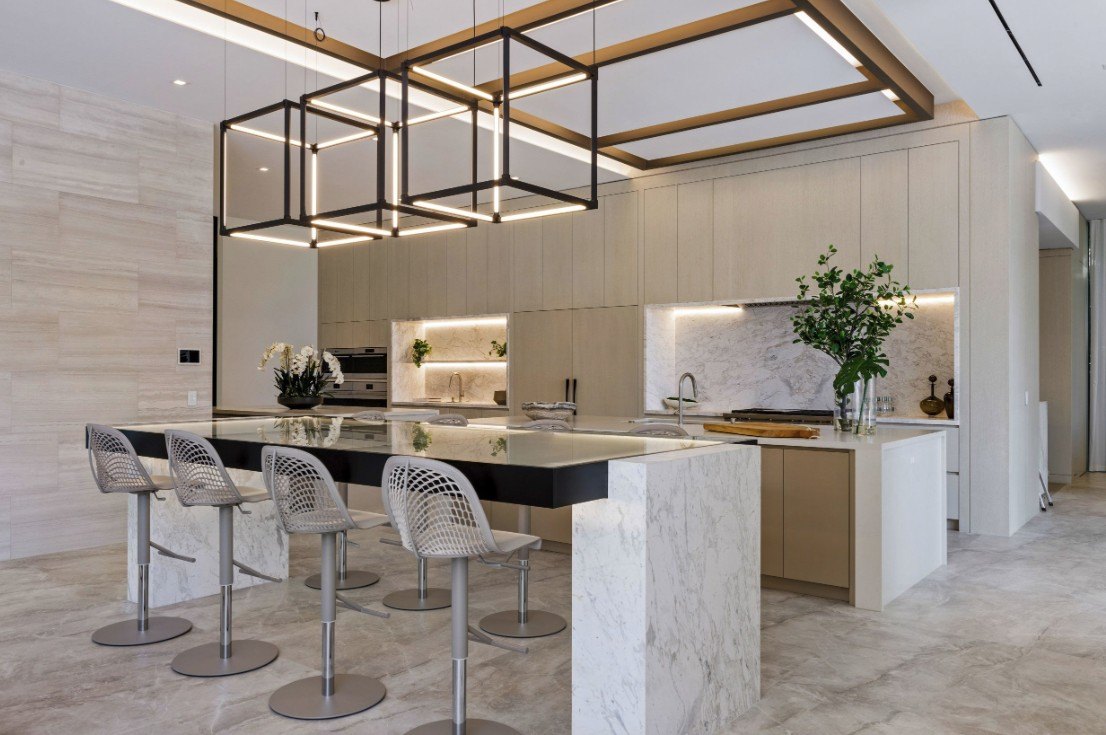 The kitchen features two large islands and a double sided dining bar.