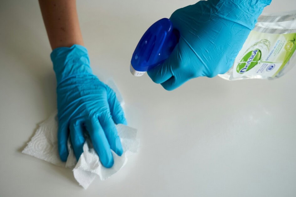 Two hands with gloves cleaning unknown surface