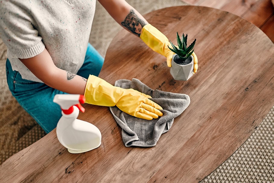 Someone cleaning a wooden coffee table 