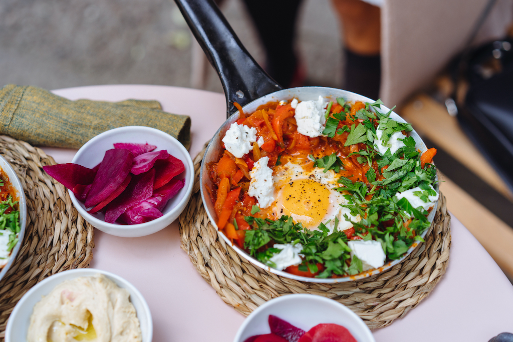 Shakshuka, Fried Eggs in Tomato Sauce on the Table. Street Restaurant