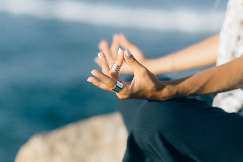 two hand rest on the knees while someone meditates and visualizes their dream home