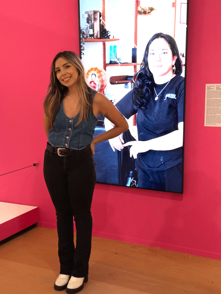 Arianna Ytselle stands in front of her rotating photography.